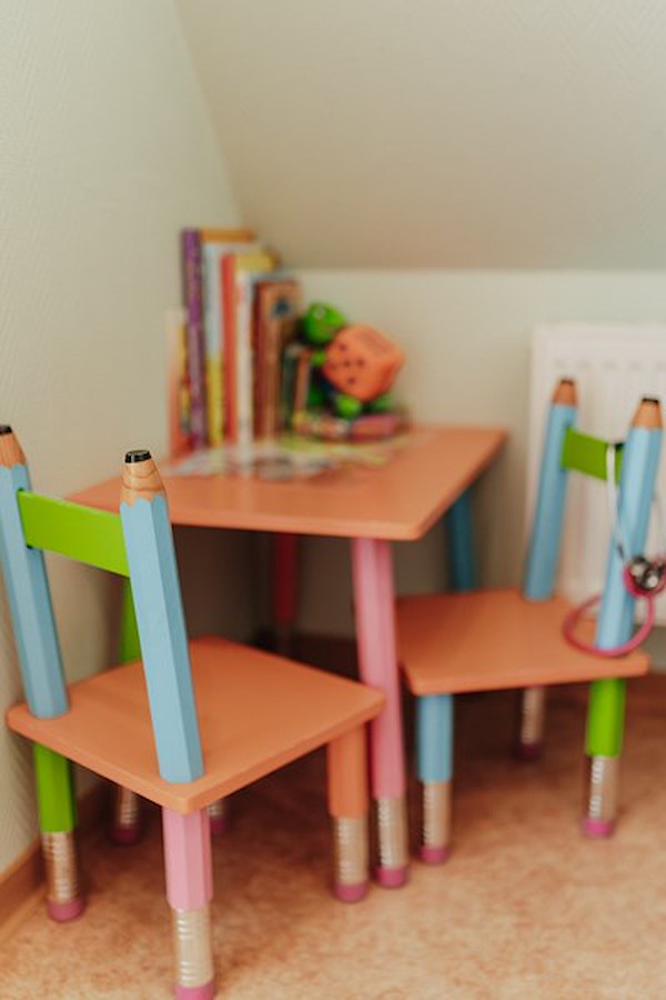 Bunter Kindertisch mit Stühlen und Büchern im Wartezimmer